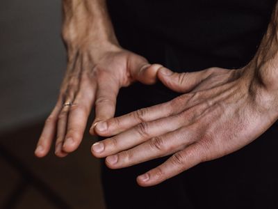 Close-up on hands in a meditative mudra position, showing concentration.
